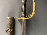 an old sword with a wooden handle next to a metal tube
