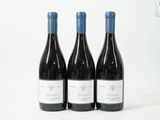 trois bouteilles de vin posées sur une table l'une à côté de l'autre