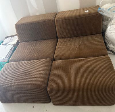 a brown couch and ottoman sitting on a white table