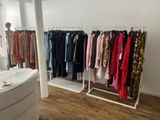 many clothes hanging on a rack in a room