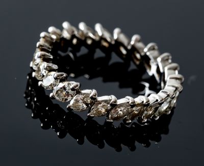 a close up of a silver bracelet on a black surface