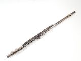 an old silver flute on a white surface with a white background