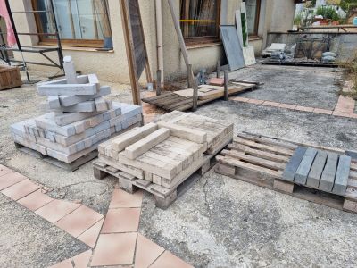 un tas de briques posé par terre à côté d'un bâtiment