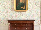 un tableau accroché au mur au-dessus d'une commode dans une pièce