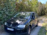the car is parked on the side of the road near the trees