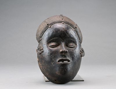 un gros plan d'un masque en bois coiffé d'un chapeau