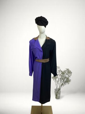 purple and black coat on a mannequin stand next to a vase of flowers
