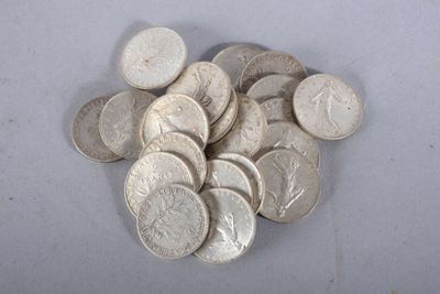 une pile de pièces d'argent posée sur une surface blanche