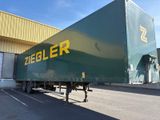 a large green truck parked in front of a building