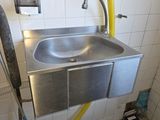 un lavabo muni d'un tuyau d'arrosage dans une salle de bains