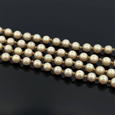 a close up of a strand of pearls on a black surface