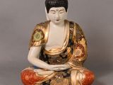 une statue représentant une personne assise en position de méditation