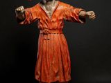 statue of a man in a red robe holding a pipe and smoking a cigarette