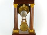a clock that is under a glass case on a table