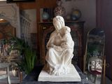 a statue of a woman holding a child on a table
