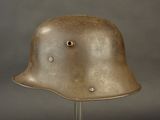 a metal helmet on a stand on a gray background