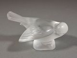 un oiseau en verre posé sur une table
