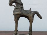 a statue of a horse that is on a wooden table