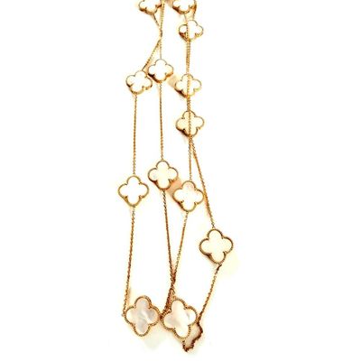 a close up of a gold necklace with flowers on it