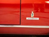 a close up of a red car with a badge on it
