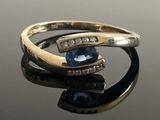 an image of a close up of a ring with a blue stone