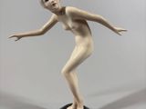 a figurine of a woman that is standing on a black base
