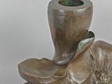 a bronze sculpture of a flower and a pipe