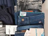 several pairs of jeans stacked on top of each other in a closet