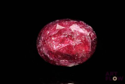 a close up of a piece of red rock on a black surface