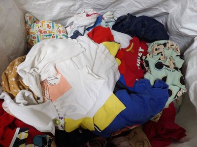 a pile of clothes that is on a bed