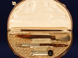 a leather case with a pen, knife, and other items in it