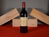 a bottle of wine sitting on a table next to two wooden boxes