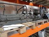 a machine that is working on a piece of wood in a factory