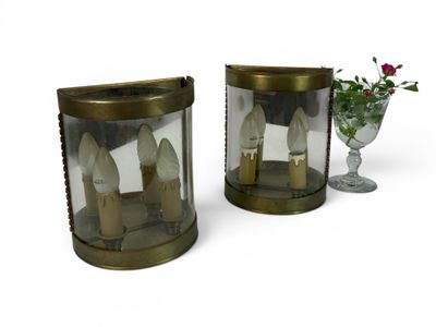 two vases with candles inside of them and a vase with flowers in it