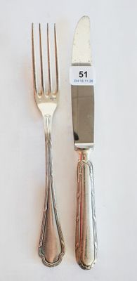 deux fourchettes et un couteau sur une table blanche
