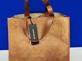 une photo d'un sac en cuir marron muni d'une étiquette