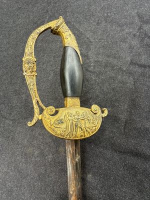 une vieille épée à la poignée dorée sur fond noir