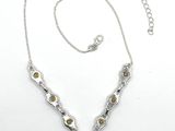 a close up of a necklace on a white surface with a chain
