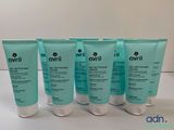 a group of five bottles of skin care on a table