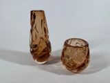pair of brown glass vases sitting on top of a white surface