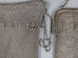 two silver metal mesh bags with a chain hanging from them