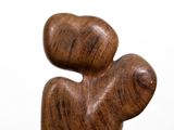a wooden sculpture that is sitting on a white surface