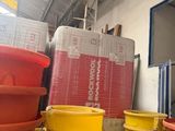 many plastic buckets stacked on top of each other in a room