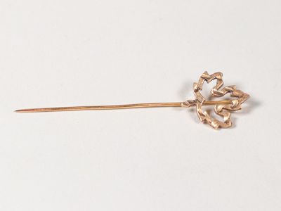 une broche en forme de fleur dorée sur un fond blanc