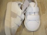 a pair of white shoes that are on a wooden floor