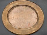a gold plate with a clock on it on a table