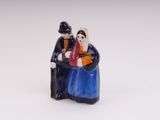 a figurine of a man and a woman sitting on a bench