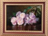 painting of three pink roses in a gold frame on a table