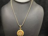 a necklace with a gold coin on a mannequin neck