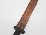 a close up of a knife with a wooden handle on a white surface